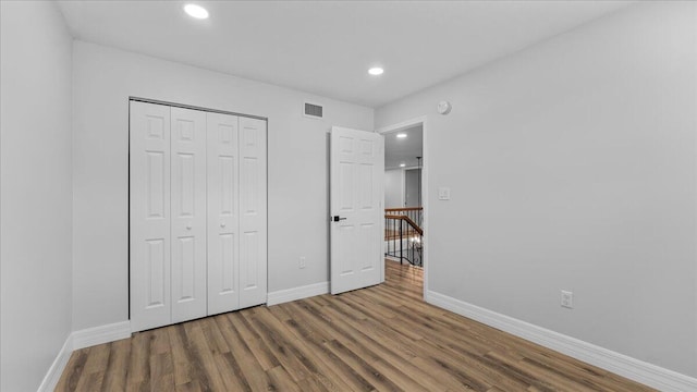 unfurnished bedroom featuring dark hardwood / wood-style floors and a closet