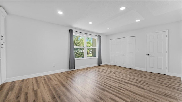 unfurnished bedroom with a closet and light hardwood / wood-style flooring