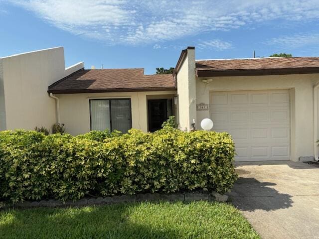 view of property exterior featuring a garage, roof with shingles, driveway, and stucco siding