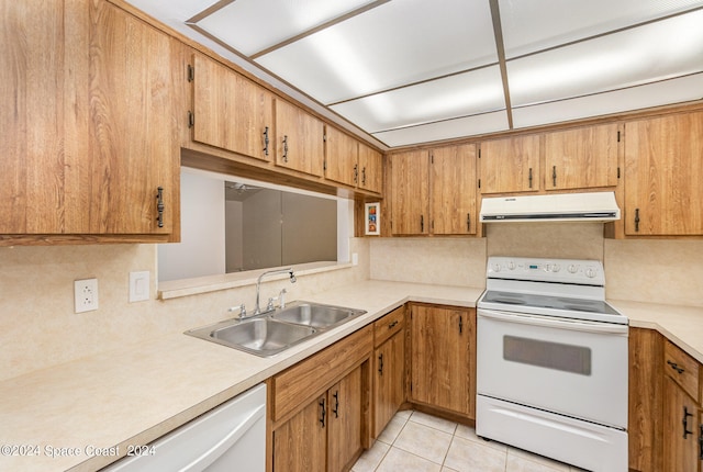 kitchen featuring sink, light tile patterned flooring, and white appliances