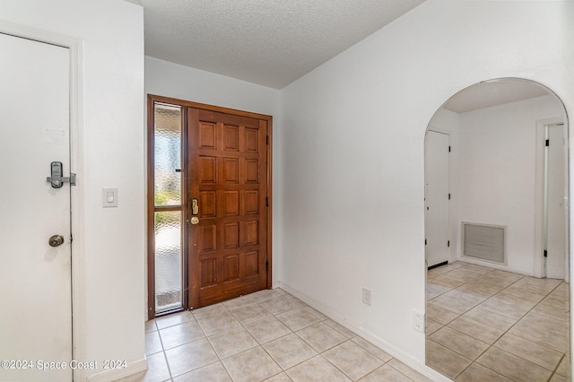 entryway featuring a textured ceiling and light tile patterned floors