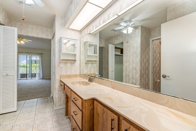 bathroom featuring ceiling fan, tile patterned flooring, a textured ceiling, and vanity