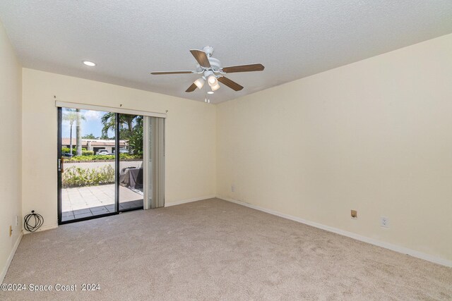 carpeted spare room with ceiling fan and a textured ceiling