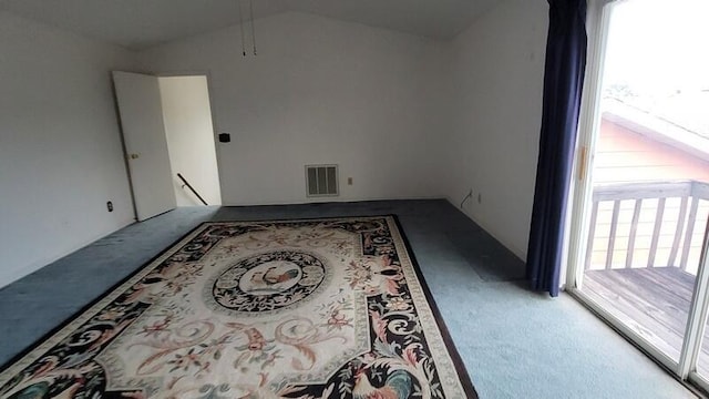 carpeted spare room featuring vaulted ceiling