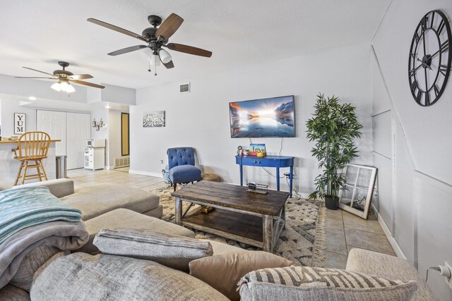 tiled living room with ceiling fan