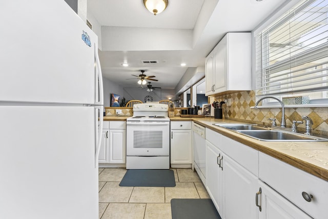 kitchen with white appliances, white cabinets, sink, backsplash, and ceiling fan