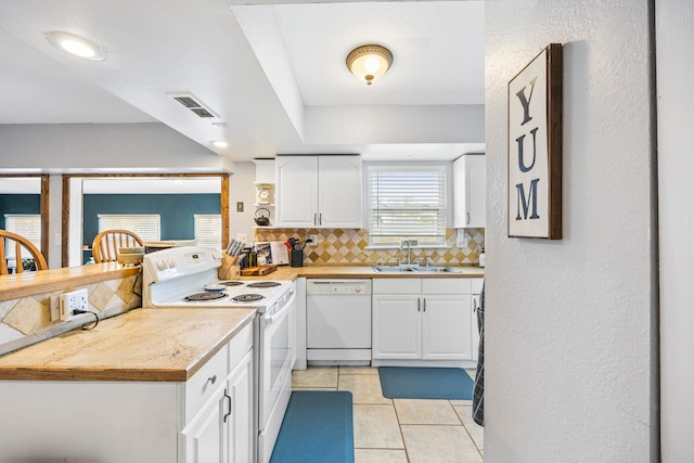 kitchen with white cabinetry, tasteful backsplash, light tile patterned floors, white appliances, and sink