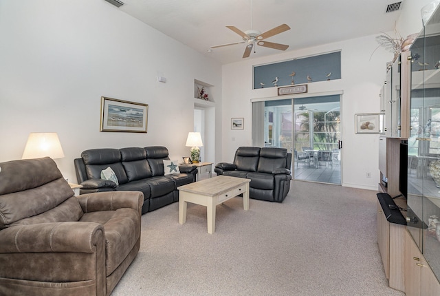 carpeted living room with a towering ceiling and ceiling fan