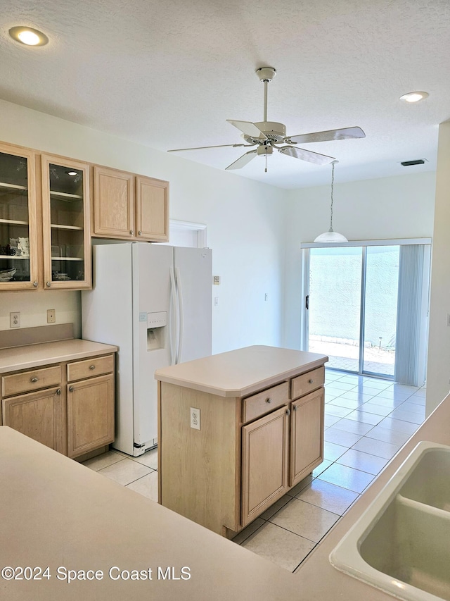 kitchen with light tile patterned floors, glass insert cabinets, white refrigerator with ice dispenser, ceiling fan, and light brown cabinets