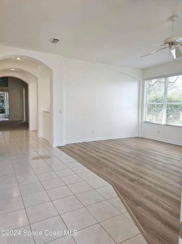 empty room with light wood-type flooring and ceiling fan