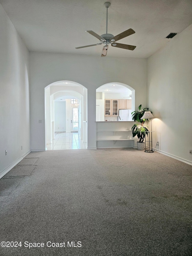 carpeted spare room featuring ceiling fan