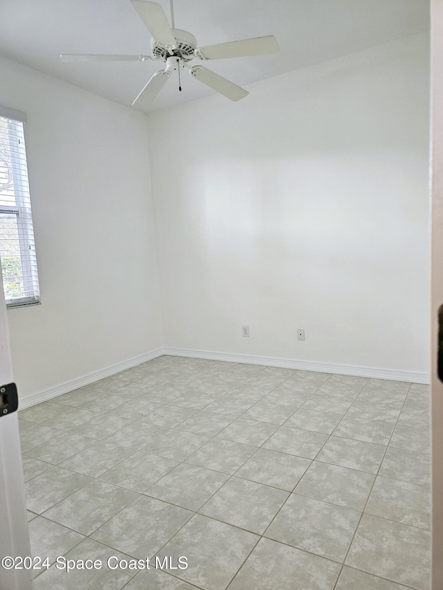 unfurnished room featuring light tile patterned floors, ceiling fan, and baseboards