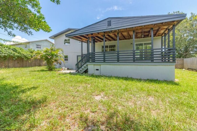 rear view of property featuring stairs, a yard, and fence