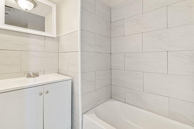 full bathroom with shower / bath combination, tile walls, and vanity