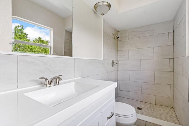 full bathroom featuring tile walls, decorative backsplash, toilet, a shower stall, and vanity