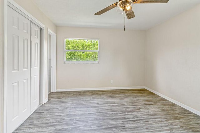 unfurnished bedroom with light wood-style floors, baseboards, a ceiling fan, and a closet