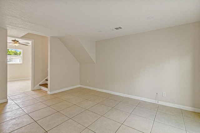 additional living space featuring light tile patterned floors, baseboards, stairs, and visible vents