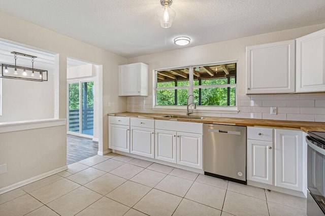 kitchen with light tile patterned floors, stainless steel appliances, a sink, and white cabinetry