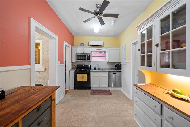 kitchen with sink, wooden counters, appliances with stainless steel finishes, backsplash, and white cabinets