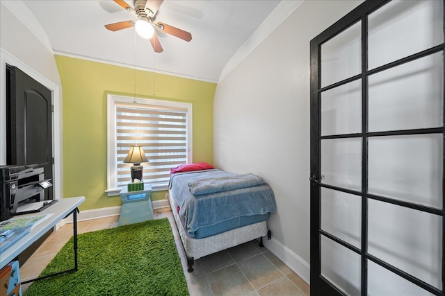 tiled bedroom with ornamental molding, vaulted ceiling, and ceiling fan