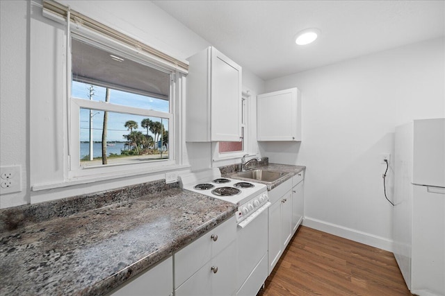 kitchen featuring sink, white appliances, dark wood-type flooring, dark stone countertops, and white cabinets