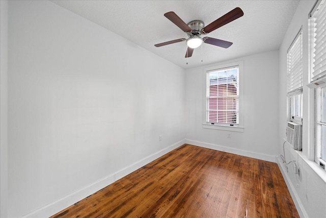 empty room with a textured ceiling, dark hardwood / wood-style floors, and ceiling fan