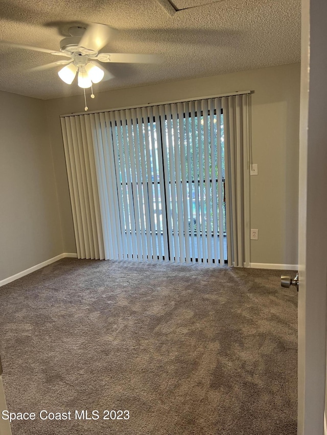 carpeted spare room with ceiling fan and a textured ceiling