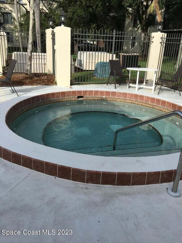 view of swimming pool with a community hot tub