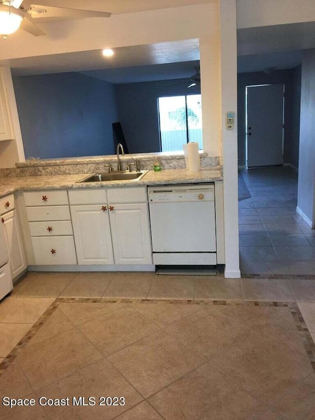 kitchen featuring white dishwasher, sink, white cabinetry, and light tile patterned floors