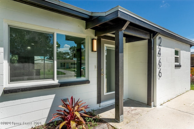 view of exterior entry with a patio