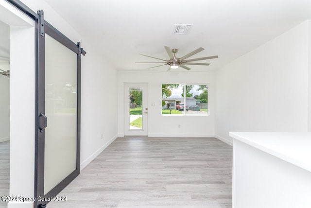 interior space featuring a barn door and light hardwood / wood-style floors