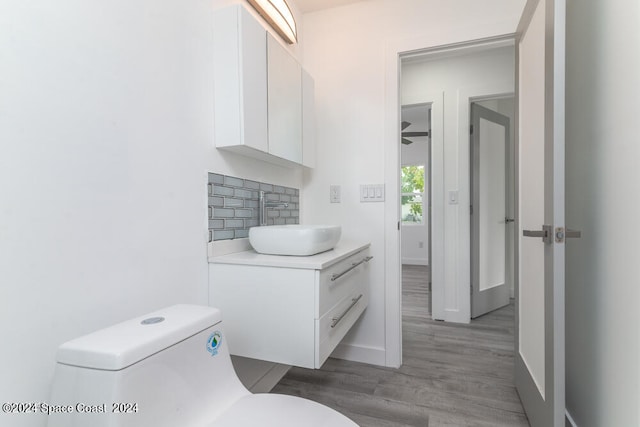 bathroom with vanity, decorative backsplash, wood-type flooring, and toilet