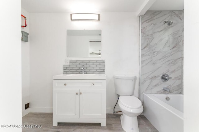 full bathroom featuring vanity, hardwood / wood-style floors, toilet, and tiled shower / bath