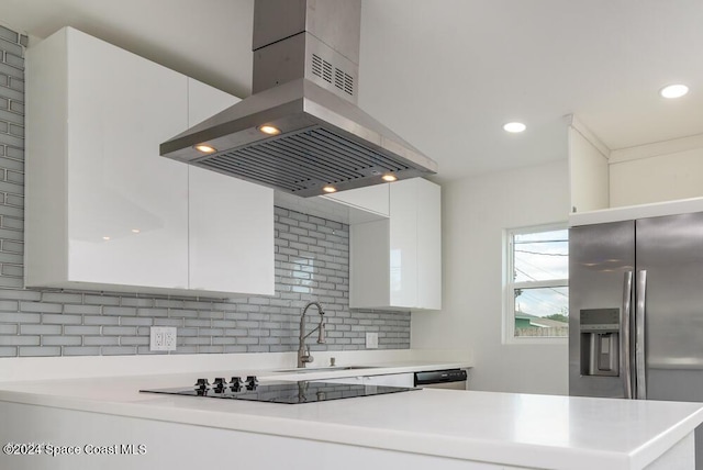 kitchen featuring appliances with stainless steel finishes, island range hood, tasteful backsplash, white cabinetry, and sink