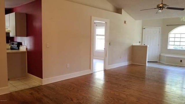 unfurnished living room with ceiling fan, light hardwood / wood-style floors, and vaulted ceiling