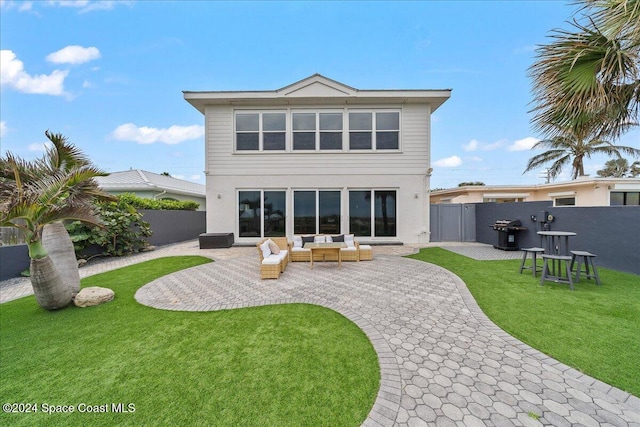 back of property with outdoor lounge area, a patio area, and a lawn