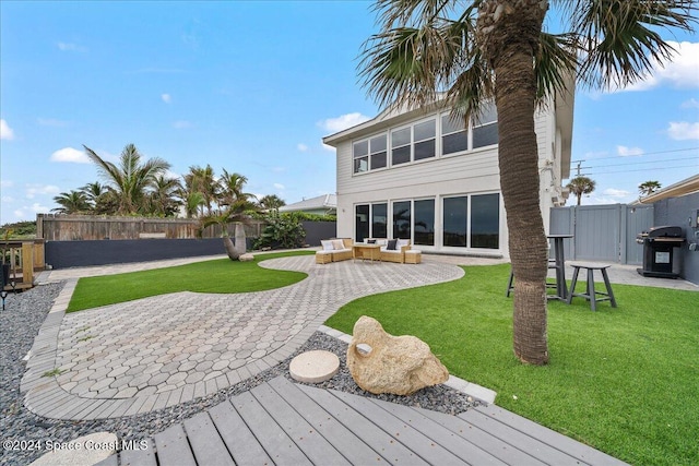 rear view of property featuring a lawn, a patio area, and an outdoor living space