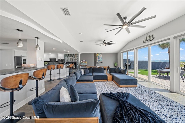 living room with ceiling fan, vaulted ceiling, and light wood-type flooring