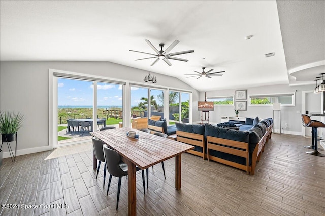 dining space with hardwood / wood-style floors, ceiling fan, and vaulted ceiling