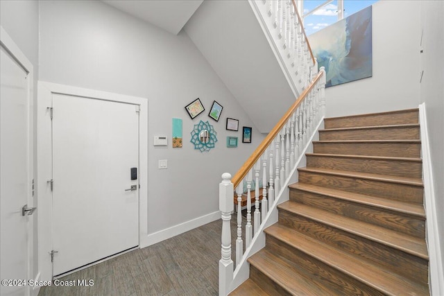 foyer entrance featuring dark hardwood / wood-style flooring and lofted ceiling