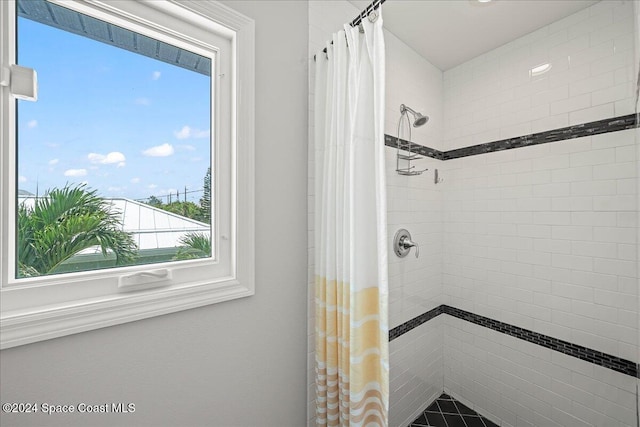 bathroom with a shower with shower curtain and a healthy amount of sunlight