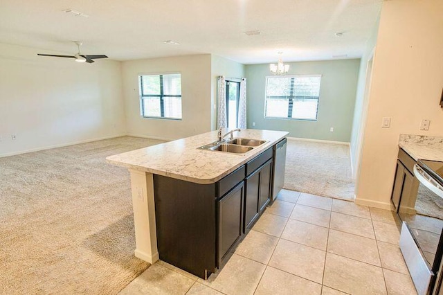 kitchen featuring a healthy amount of sunlight, sink, a kitchen island with sink, and light carpet