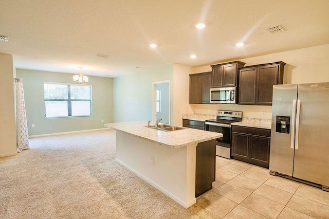 kitchen featuring appliances with stainless steel finishes, sink, a chandelier, a kitchen island with sink, and light carpet