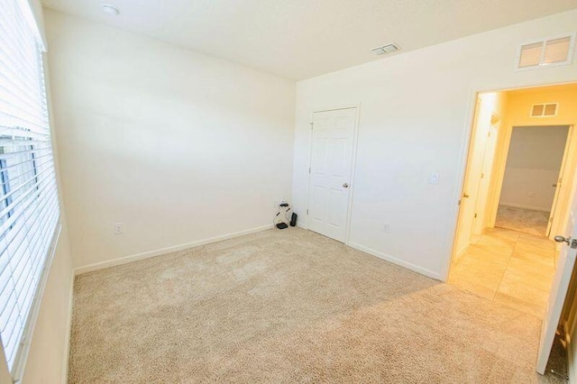 spare room featuring light carpet