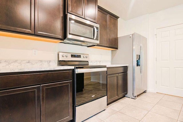 kitchen with stainless steel appliances, dark brown cabinets, and light tile patterned floors