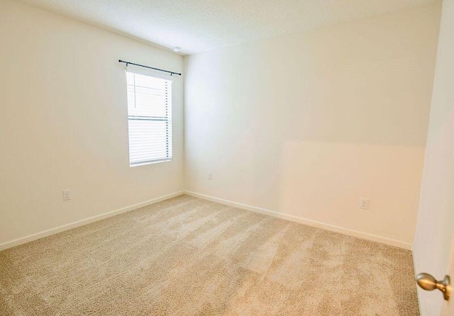 unfurnished room featuring light colored carpet