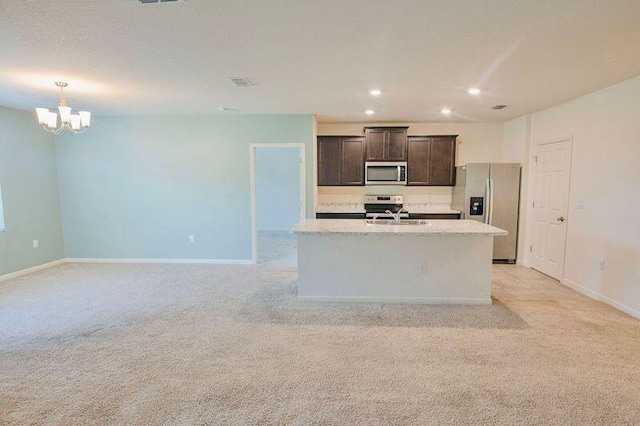 kitchen with stainless steel appliances, a center island with sink, light colored carpet, and dark brown cabinetry