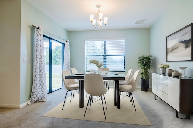 carpeted dining space featuring an inviting chandelier