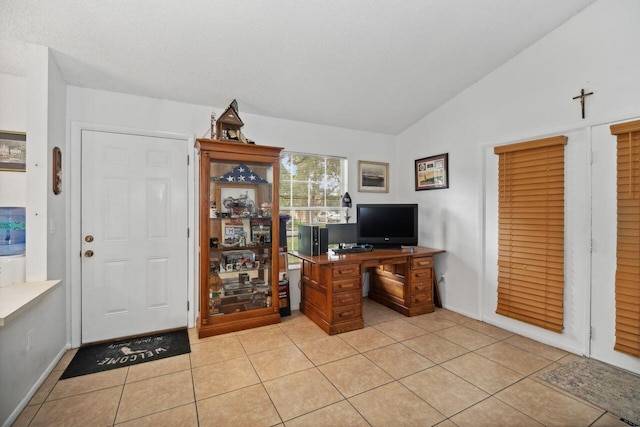 office area with vaulted ceiling and light tile patterned floors