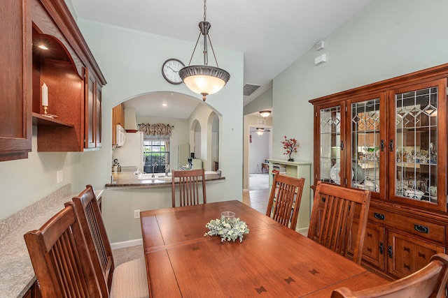 tiled dining room featuring lofted ceiling